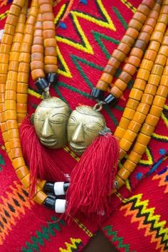 two masks are placed next to corn on the cob, with other beads and decorations