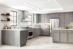 a large kitchen with gray cabinets and white counter tops, along with an island in the middle