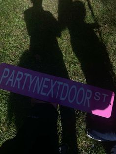 the shadow of two people holding up a purple sign that says party next door st