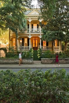 two people are walking in front of a house