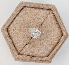 an engagement ring sitting on top of a cushion