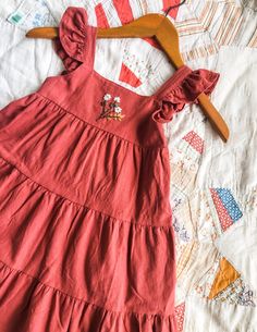 "Rusty Red Cotton Dress - Size 6 This dress is one of my favorites! The sweet ruffle flutter sleeves are precious, it swirls just like a little girl wants her dress to swirl and the hand embroidery really adds the sweetest touch. All hand embroidery is done by us! Free handed with lots of love! Size 6 Measures approximately 24\" from top of sleeve to bottom hem Wash/Care: I always recommend hand washing anything hand embroidered to keep stitches nice and neat. Hang/lay flat to dry. Please message us with any questions you may have :)" Cute Spring Embroidered Cotton Dress, Cute Cotton Embroidered Spring Dress, Cute Summer Embroidered Cotton Dress, Spring Embroidered Dress For Dress-up, Cute Sleeveless Dress With Floral Embroidery, Cute Embroidered Cotton Dress, Red Sleeveless Dress With Floral Applique, Spring Cotton Embroidered Dress With Machine Embroidery, Cotton Embroidered Dress With Machine Embroidery For Spring