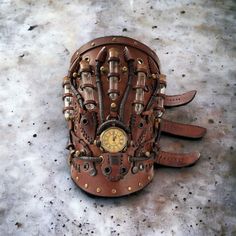 a baseball glove that is sitting on the ground with a clock in it's middle