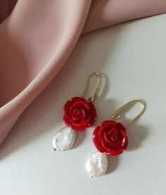 Drop earrings made of: - Baroque Pearl drops (18 mm x 12 mm), white color; - Resin Roses, red color; - Gold plated 925 Silver hooks. Lenght : 5 cm / 1,97 inches * SHIPPING * Your order will be shipped within 1-3 business days from your purchase. You can choose between 2 shipping methods: STANDARD MAIL (NOT TRACEABLE) It is a cheap and fast shipping method, but NOT TRACEABLE. Chapeau Atelier is not responsible for any postal disruptions, delays or losses. REGISTERED MAIL (TRACEABLE) It is an abso Elegant Rose Flower Earrings For Gift, Elegant Handmade Red Flower Earrings, Elegant Red Handmade Flower Earrings, Elegant Handmade Rose Jewelry, Elegant Red Flower Earrings For Anniversary, Red Dangle Jewelry With Rose Design, Red Rose Design Dangle Jewelry, Red Rose Design Drop Earrings, Red Rose Jewelry For Anniversary