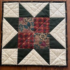 a quilted table topper on a wooden surface