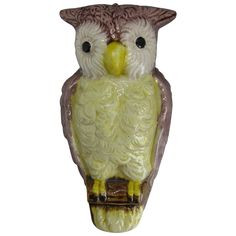 an owl figurine sitting on top of a tree branch