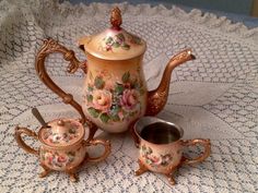 an antique tea set on a lace tablecloth