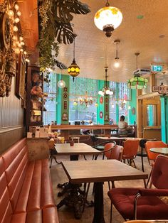 the interior of a restaurant with tables, chairs and lights hanging from the ceiling above