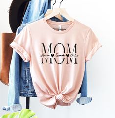 Mom Shirt, Kids Names Shirt, Personalized Mom Shirt, Custom Mom Shirt, Mothers Day Shirt, Mom Birthday Gift, Gift for Mom, Mama Shirt HOW TO PLACE YOUR ORDER * Choose your t-shirt color * Choose your size * Choose your design&text color * PLEASE make sure all your order's steps PRODUCT DESCRIPTION T-shirt feels soft and light, with just the right amount of stretch. It's comfortable and the unisex cut is flattering for both men and women. * Solid colors are 100% combed and ring-spun cotton * Ash Mom Tshirt Ideas Design, Personalized Pink T-shirt For Mother's Day, Long Sleeve T-shirt For Mother's Day Birthday, Custom Text Long Sleeve T-shirt For Mother's Day, Personalized T-shirt For Spring Gift, Name Print Top For Birthday And Mother's Day, Family Matching Tops With Letter Print For Birthday Gift, Birthday Shirt For Mother's Day With Crew Neck, Pink Tops For Mother's Day Gift