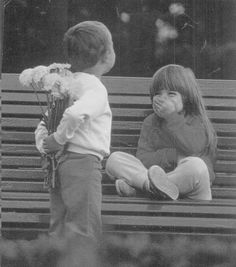 a newspaper article with an image of two children sitting on a bench and one holding flowers