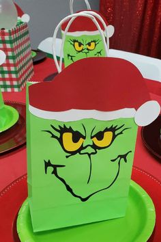 a green bag with an angry grin face on it sitting on top of a table