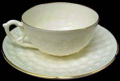 a white cup and saucer sitting on top of a plate