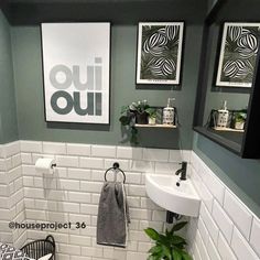 a bathroom with green walls and white tile on the floor is decorated in black and white