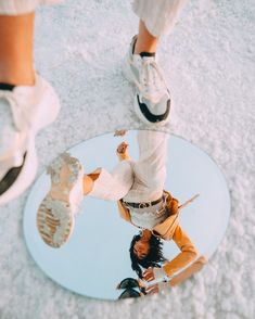 a person standing in front of a mirror with their feet on the ground and one leg up