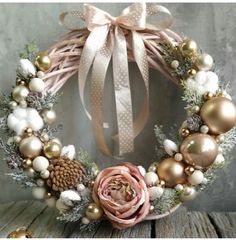 a christmas wreath with pine cones, ornaments and a pink rose on the front door