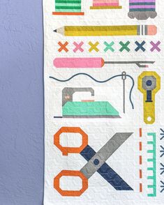 a quilted wall hanging with scissors and sewing supplies