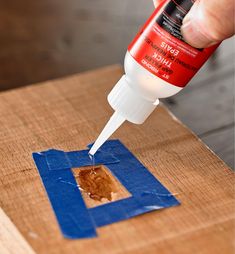 a person using glue to paint the edges of a piece of wood