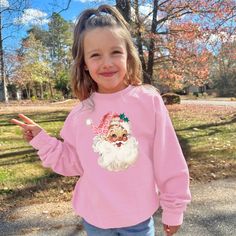 This cozy crewneck is the perfect gift for a girl or woman. Featuring the cute pink santa with leopard print hat, this shirt is stylish and cute winter wear. 𝐇𝐎𝐖 𝐓𝐎 𝐎𝐑𝐃𝐄𝐑 1. Select the size & color when applicable 2. Add the personalization (name, design etc) when required 3. Add to Cart & submit your order. 4. If ordered over $35, we have FREE shipping for you! 𝐀𝐋𝐖𝐀𝐘𝐒 𝐇𝐀𝐍𝐃𝐌𝐀𝐃𝐄 * Each item is handmade and made to order here in Florida! * We carry several different brands and use different brands for different listings, including Rabbit Skins®, Gildan®, Gerber Onesie®, Bella Canvas® and Comfort Colors®. G A R M E N T ∙ F E A T U R E S : * Unisex Fit * Commercial grade heat press S H I P P I N G * All items get sent via USPS first class mail * Priority 2-3 day shippin Cute Long Sleeve T-shirt For Holiday, Holiday Pink Long Sleeve Tops, Pink Long Sleeve Holiday Top, Trendy Winter Tops With Cartoon Print, Long Sleeve Cartoon Print T-shirt For Winter, Pink Letter Print Top For Winter, Winter Pink Top With Letter Print, Pink Tops With Letter Print For Winter, Trendy Winter T-shirt With Cartoon Print