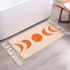 an orange and white rug on the floor next to a bath tub