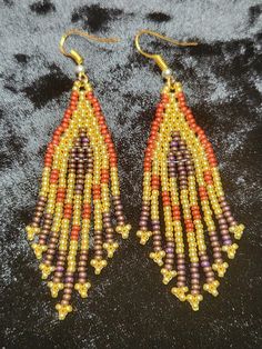 Gold, red, and brown glass seed bead earrings. Beautiful for any occasion. Traditional Gold Beaded Earrings With Colorful Beads, Brown Gold Beads Jewelry For Party, Traditional Gold Earrings With Faceted Beads, Brown Dangle Beaded Earrings With Tiny Beads, Traditional Brown Beaded Earrings With Tiny Beads, Gold Bohemian Beaded Earrings With Faceted Beads, Brown Dangling Beads Jewelry For Party, Brown Earrings With Colorful Beads For Gift, Brown Copper Beaded Earrings For Gift