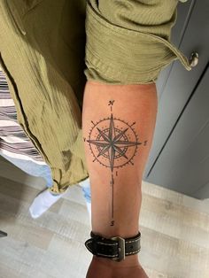 a person with a compass tattoo on their arm