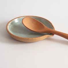 two wooden spoons sitting on top of a ceramic bowl next to each other,