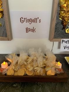 a table topped with lots of cookies next to a framed sign that says grinott's book