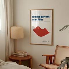 a poster hangs on the wall above a bed in a room with a chair and lamp