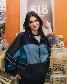 a woman standing in front of a display of perfumes