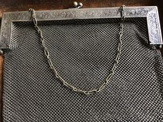 "This is an excellent evening bag - if you don't' wish to conceal anything in it. It is lovely. The bag is comprised of a chain mail mesh in German silver which descends from a stamped frame of German silver with a silvered brass clasp and chain. It is marked on its handle with an eye pictogram and the words German silver. The eye indicates that is was made by JT Inman, a silver company founded in Attleboro MA in 1882. The bag is pretty large for its type. It is 10\" wide X 9\" long. The chain i Silver Chain Bag For Event, Silver Clutch With Chain For Gifting, Silver Metal Chain Link Bag, Silver Rectangular Evening Bag With Chain Strap, Elegant Silver Bag With Chain, Elegant Silver Bags With Chain Detail, Formal Silver Bag With Chain, Silver Evening Bag With Chain For Gift, Silver Metal Formal Bags