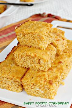 sweet potato cornbread squares stacked on top of each other in a white square plate