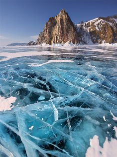 an ice covered lake with mountains in the background