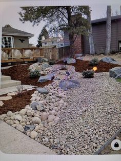 a fire hydrant sitting in the middle of a gravel and stone garden area next to a house