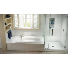 a bathroom with a walk in shower next to a bathtub and sink under a window