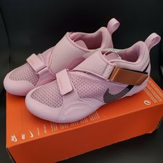 a pair of pink shoes sitting on top of an orange box