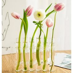 several vases with flowers in them sitting on a table