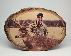 a man is posing with a deer in front of him on a wood slice that has been cut into smaller pieces