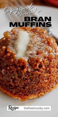 a close up of a muffin on a plate with a fork and spoon in the background