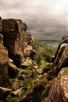 some rocks and grass under a cloudy sky