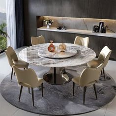 a round marble dining table surrounded by beige chairs