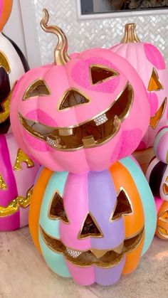 three pumpkins are stacked on top of each other with faces painted on them,