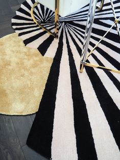 black and white striped rugs on the floor next to a chair in a room