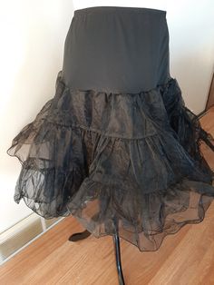 "Vintage Womens Black Nylon Full Circle Petticoat Slip/ Pin Up Rockabilly Half Slip Size M-L Very Good Vintage Condition. No Rips, Tears Or Stains. Elastic Has Probably Lost Some Of It's Stretch. If Replaced Could Fit A Size Small Also. .5\" Elastic Nylon Stretchy Top Section 2 17\" Tiered Stiff Nylon Ruffled Sections Nylon Undercoat Waist 30\"-43\" Hips 50\" Length 26\"" Can-can Petticoat For Costume Party, Party Skirt With Can-can Crinoline, Party Can-can Petticoat With Tiered Skirt, Black Crinoline Full Skirt Petticoat, Black Full Skirt Crinoline Petticoat, Black Fitted Petticoat For Party, Vintage Party Skirt With Attached Cancan, Vintage Full Skirt Petticoat For Costume, Stretch Petticoat For Costume Party