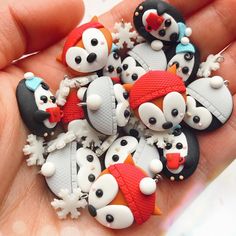 a hand holding a bunch of small buttons with animals on it's backs and faces