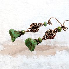 Sage green Boho earrings made with Czech glass beads. Beautiful handmade glass flowers have a Picasso finish that gives them depth and a feeling of being in forest. These long green dangle earrings are perfect for the nature lover, they evoke the forest. Mossy sage green is trending now!  Available in antique copper, silver or brass. Select metal finish in dropdown menu. Hypoallergenic ear wires (nickel and lead free). Choose ear wire style at checkout.  Free gift packaging included. Earrings ar Czech Glass Dangle Earrings With Bead Caps, Green Flower-shaped Jewelry With Dangling Beads, Green Dangling Bead Flower Earrings, Green Adjustable Dangle Flower Earrings, Green Dangle Flower Earrings With Beads, Green Copper Bead Earrings, Green Dangle Earrings With Dangling Beads, Green Flower Drop Earrings With Dangling Beads, Green Copper Round Bead Earrings