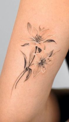 a woman's thigh with flowers tattooed on the side of her leg and arm