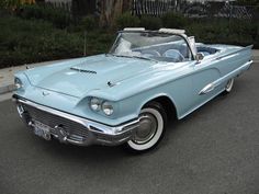 an old blue car is parked on the street