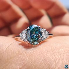 a blue and white diamond ring on someone's hand