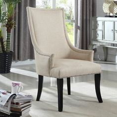 a white chair sitting in front of a window next to a potted palm tree