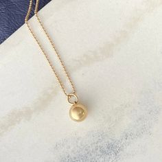 Made of solid 14k gold, our sphere charm symbolizes completeness and connection for those who wear it. It embodies the essence of our Golden Geometry collection, showcasing the beauty of form, the precision of mathematics, and the timeless allure of nature's perfect shapes. the Sphere pendant is available in solid 14k gold + sterling silver all charms come on a 14k gold ball chain necklace pendants are first hand carved in wax and then cast in either 14k gold or sterling silver perfect for every Gold Pendant Necklace With Ball Chain, Elegant Jewelry With Round Pendant Ball Chain, Elegant Jewelry With Ball Chain And Round Pendant, Classic 14k Gold Ball Chain Necklaces, Everyday Yellow Gold Charm Necklace With Pearl Pendant, Minimalist Jewelry With Round Pendant Ball Chain, Minimalist Round Ball Chain Jewelry, Yellow Gold Pendant Charm Necklace With Satellite Chain, Minimalist Jewelry With Ball Chain And Round Pendant